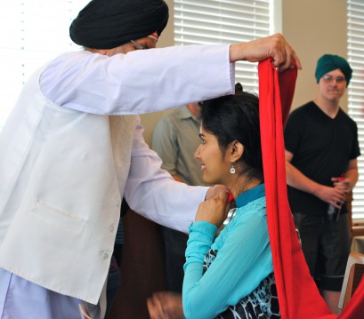 A member of the Sikh Temple of Spokane wraps an Eastern Washington University student's head with a turban/Tracy Simmons 