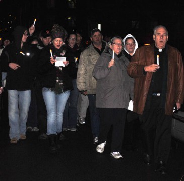 A group walks with candles around the House of Charity in Spokane. 