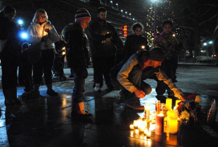 A man lights candles in honor of school shooting victims 