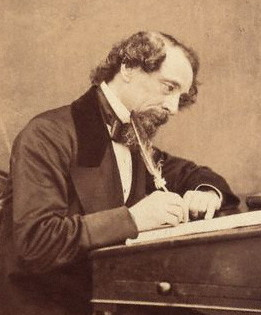 Charles Dickens writing at his desk in 1858.   