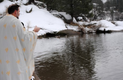 Fr. Stephen Supica throws a cross into the Spokane River 