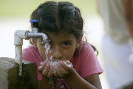 A girl in Guatemala drinks from a well provided from Water for Life. 