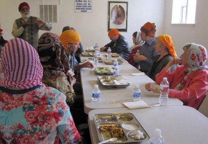 Faith Feast guests learn about Sikhism while eating an entree at the Sikh Gudwara of Spokane. 