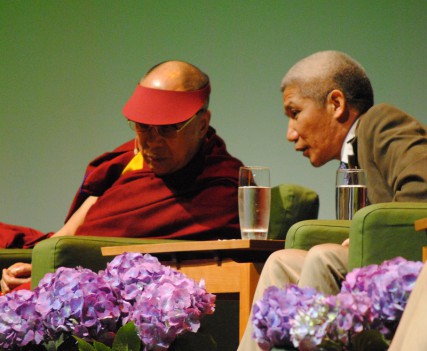 The Dalai Lama's translator explains a question during an environmental summit in Portland. 