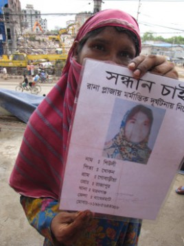 Ranjana Akhter, 35, holds a picture Wednesday of her missing daughter Sheuli Akhter, 20, while standing opposite the ruins of Rana Plaza where Sheuli worked. The building, packed with garment factories on illegally built additional stories, collapsed April 24 in a suburb of the Bangladesh capital Dhaka. 