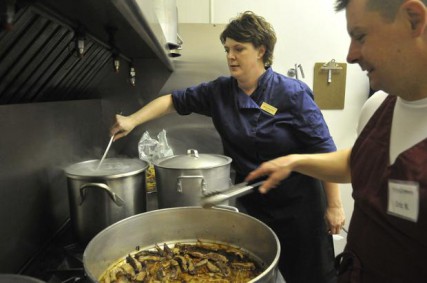 Chef Erin Streicher, left, stirs pasta as volunteer cook Eric Nelson, right, browns beefs at the Women and Children?s Free Restaurant in the basement of Christ of Hope Open Bible Church on North Monroe Street on Aug. 21. Streicher overseas the kitchen which makes meals from donated food items. 