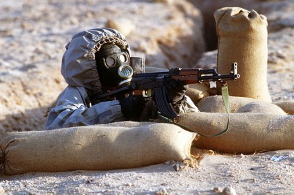 A Syrian soldier aims an TYPE 56-1S (China made AK47) assault rifle from his position in a foxhole during a firepower demonstration, part of Operation Desert Shield in the 1990s. 