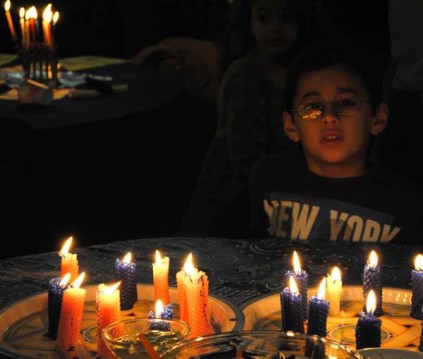 The final menorah candle is lit during a Hanukkah celebration. 