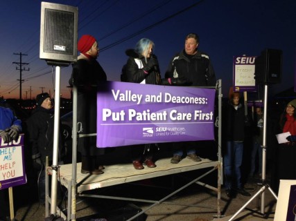 Local leaders stand with hospital workers.