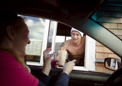 Chris Mullins, owner of Hot Cup of Joe, hands customer Kayte Gier her espresso drink Wednesday. The espresso stand at the intersection of Ash Street and Spofford Avenue in Spokane features shirtless barista men. Colin Mulvany photo/Spokesman-Review