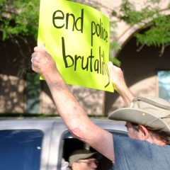 Tom Schmidt waves a "end police brutality sign"/Tracy Simmons - SpokaneFAVS