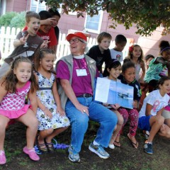 Bishop James Waggoner reads about airplanes to a group of children at Stone Soup Cafe