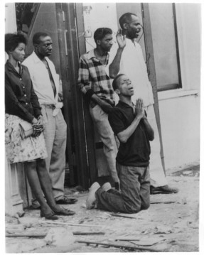 (1963) A man falls to his knees in prayer amid shattered glass from windows of the 16th Street Baptist church and surrounding buildings in Birmingham, Ala. Four young girls dies as a racist's bomb exploded at 10:22 a.m. on Sept. 15 during worship services and Sunday school sessions.  In the following outbreak of violence throughout the area, two young black men were shot to death. Pleas for effort to stop further bloodshed were issued from government, civil rights and religious leaders across the nation. Religion News Service file photo