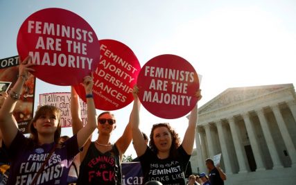 Demonstrators hold signs outside the U.S. Supreme Court as the court is due to issue its first major abortion ruling since 2007 against a backdrop of unremitting divisions among Americans on the issue and a decades-long decline in the rate at which women terminate pregnancies in Washington, U.S. June 27, 2016. REUTERS/Kevin Lamarque